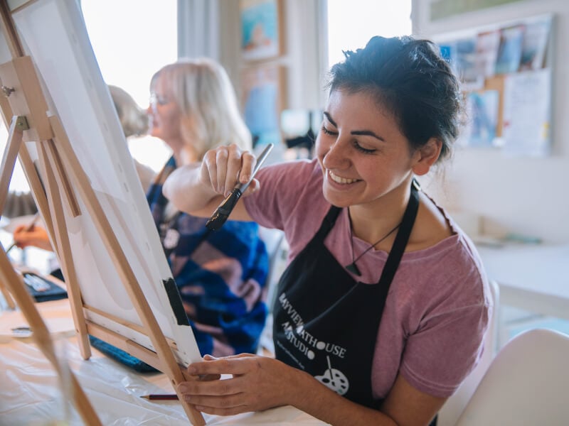 woman smiling at paint and sip class
